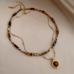 Double-layer layered Maillard beaded necklace with tiger's eye stone pendant, retro sweater chain for autumn and winter.